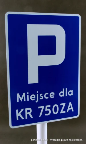 Tabliczka parkingowa zamontowana przy pomocy uchwytów montażowych. 