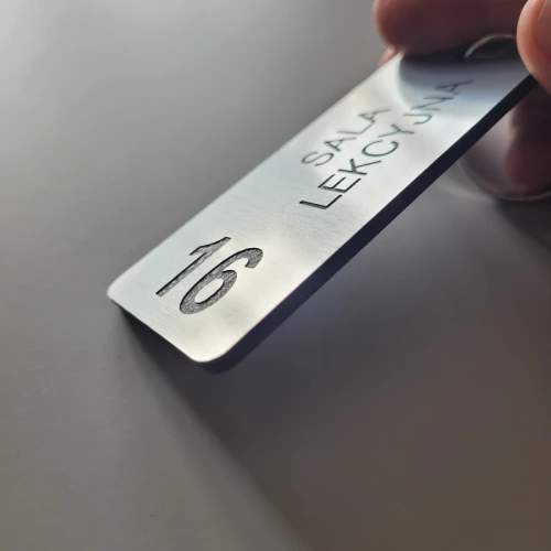 Numerek do kluczy z grawerem mechanicznym kolor stalowy szczotkowany.