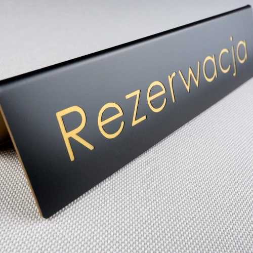 Rezerwacja-tabliczka-czarna-złoty-napis-grawerowany.JPG