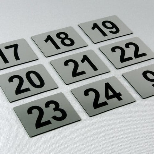 Kilka przykładowych tabliczek z numerami w kolorze stalowym szczotkowanym