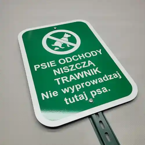 Psie odchody niszczą trawnik Nie wyprowadzaj tutaj psa Tabliczka na metalowym słupku