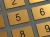 Kilka małych grawerowanych numerków w kolorze złotym szczotkowanym