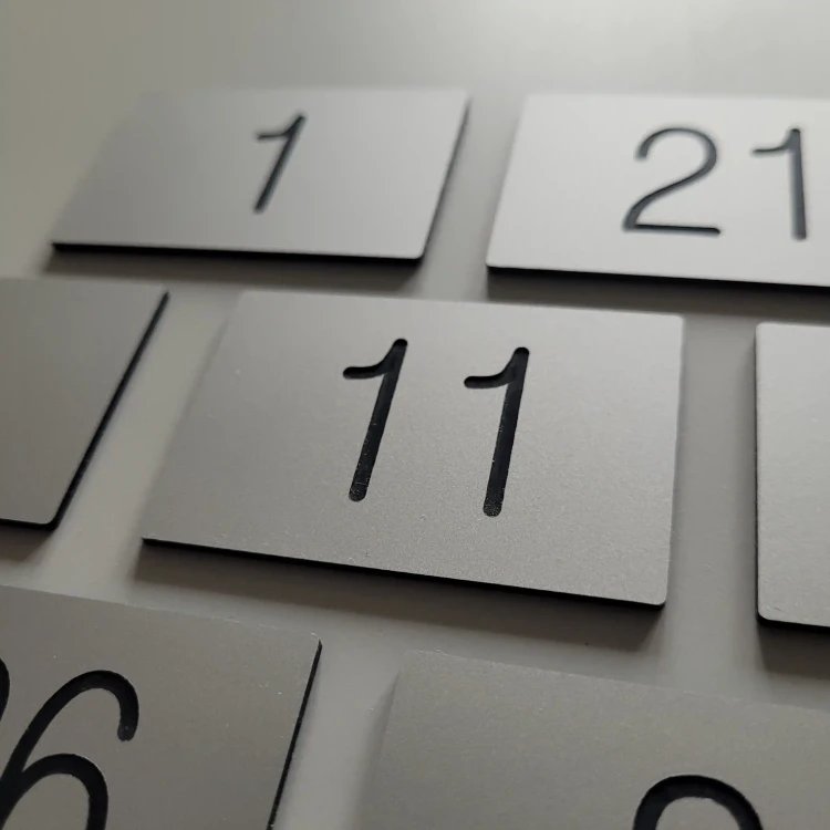Małe tabliczki z numerami grawerowanymi w kolorze srebrny