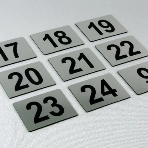 Kilka przykładowych tabliczek z numerami w kolorze stalowym szczotkowanym